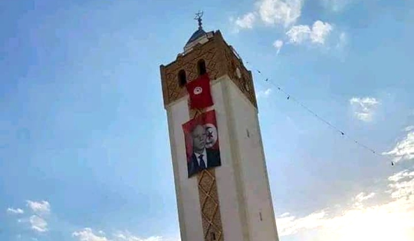 Une photo gante de Kas Saed placarde sur un minaret